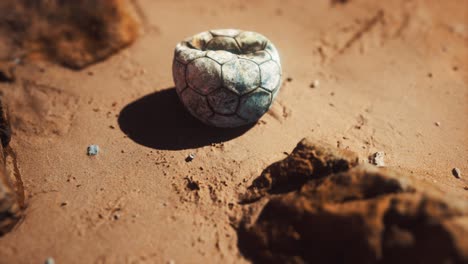 old-football-ball-on-the-sand-beach